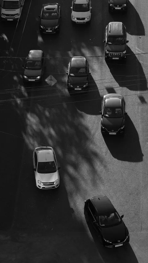 A striking aerial shot capturing urban traffic in grayscale, highlighting city life dynamics.