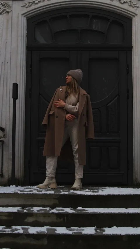 Chic winter street style portrait of a woman in a coat and beanie.