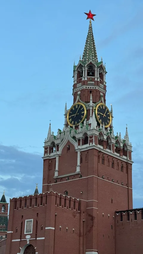 View of the iconic Spasskaya Tower in the Moscow Kremlin against a clear blue sky.