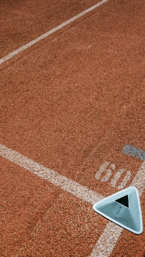 Detailed view of a running track with lane markings and a triangular lane marker.