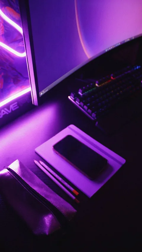 A modern workspace featuring a glowing computer setup with neon lights.